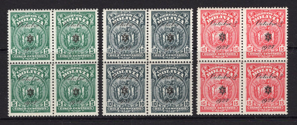 BOLIVIA - 1928 - MULTIPLE: 5c green, 10c grey and 15c carmine 'Arms' issue with 'Octubre 1927' overprint, the set of three in fine unmounted mint blocks of four. (SG 207/209)  (BOL/18534)