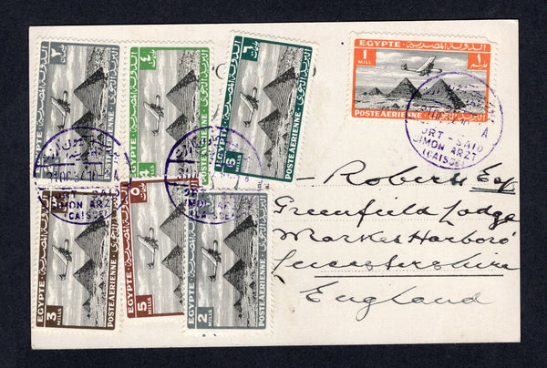 EGYPT - 1937 - AIRMAIL & CANCELLATION: Real photo PPC 'The passage in the desert' showing camels crossing the desert with lovely franking of 1933 1m black & orange, 2 x 2m black & grey, 3m black & sepia, 4m black & green, 5m black & chocolate and 6m black & blue green AIR issue (SG 193/194 & 196/199) all tied by PORT - SAID SIMON ARZT (CAISSE) cds's in bright purple. Addressed to UK. Very attractive.  (EGY/18751)